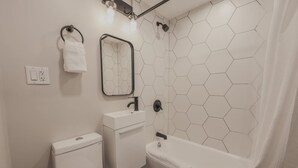 Een badkamer met toilet, wastafel en bad.