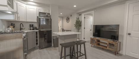 A modern kitchen with a central island, a built-in stove, and a refrigerator.
