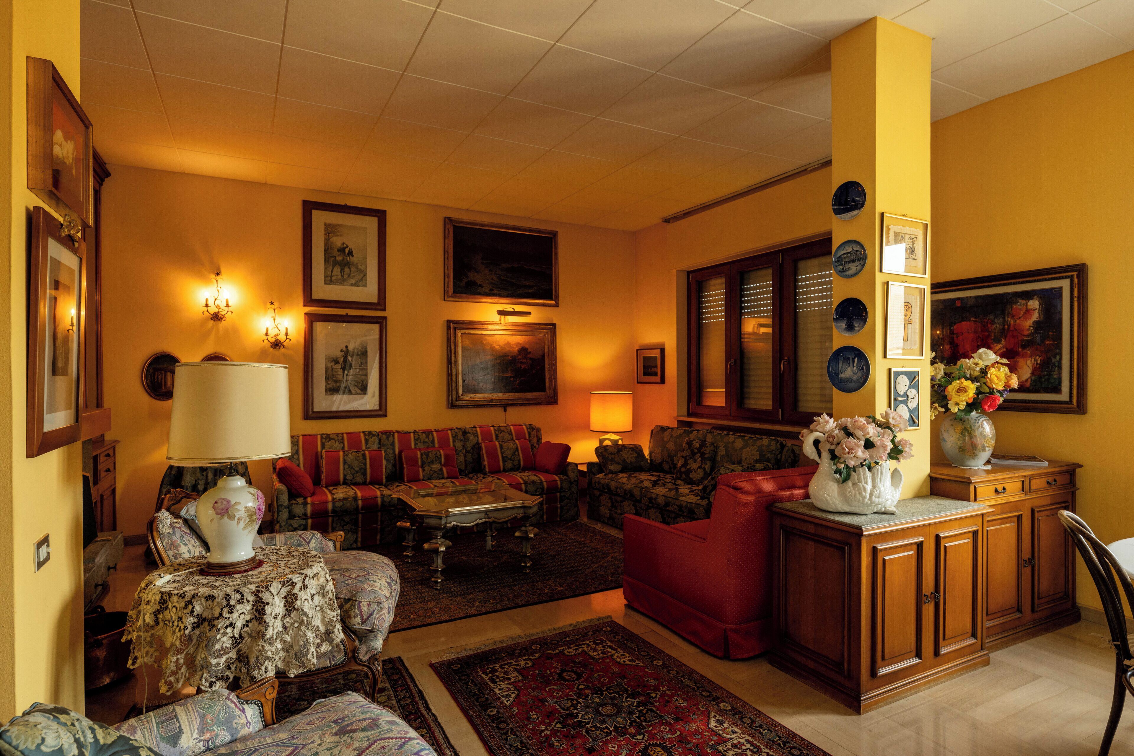 A living room with a sofa set, a coffee table, a patterned rug, and wall-mounted artwork.