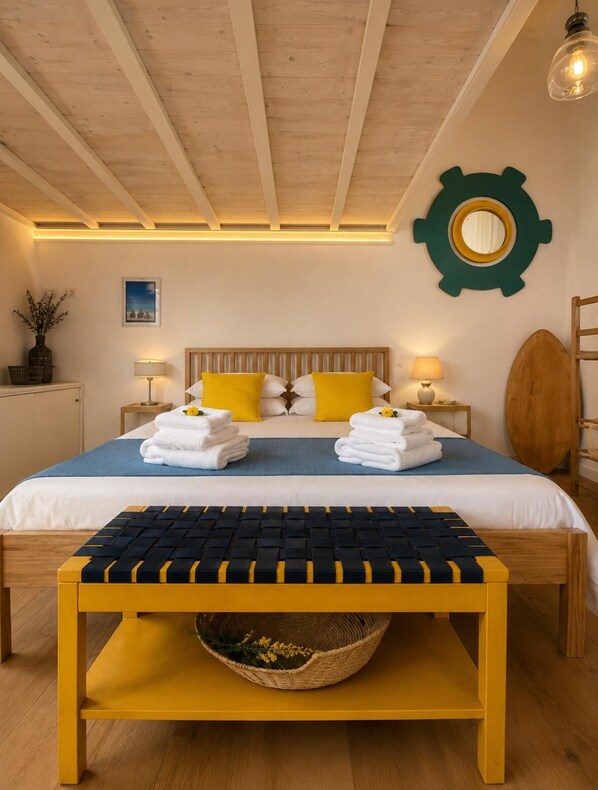 A double bed with a wooden headboard, two bedside lamps, and a round mirror on the wall. - Vrbo Property (Bacoli)