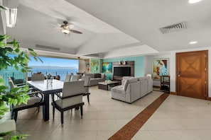 A spacious living area with a dining table, sofas, and a TV. - Grand Venetian Oceanfront by Monyxbnb (Puerto Vallarta)