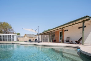 A clear swimming pool with lounge chairs and a covered patio area. - Modern Mesa Retreat Pool Near Gilbert & US-60 (Mesa)