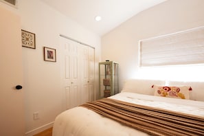 A bedroom with a bed, a wardrobe, a window with blinds, and a wall-mounted shelf. - Modern Mesa Retreat Pool Near Gilbert & US-60 (Mesa)