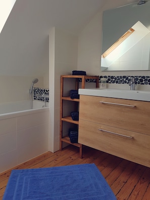 A bathroom with a bathtub, wooden shelves, a sink, and a mirror. - ☼ The Charm of Baulois: Villa Passiflore ☼ (La Baule-Escoublac)