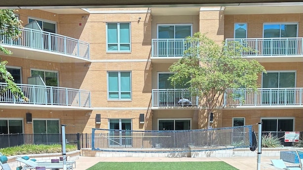 A courtyard with artificial grass, lounge chairs, and a concrete table. - Preston Royal Single II I Premium 1BR in Dallas (Dallas)