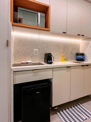 A kitchen with a microwave, coffee maker, and a dishwasher.
