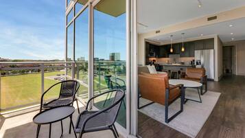 A modern interior with a balcony, large windows, and a kitchen area.