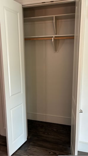 A walk-in closet with a wooden rod and a white door. - Preston Royal Single I Premium 1BR in Dallas (Dallas)