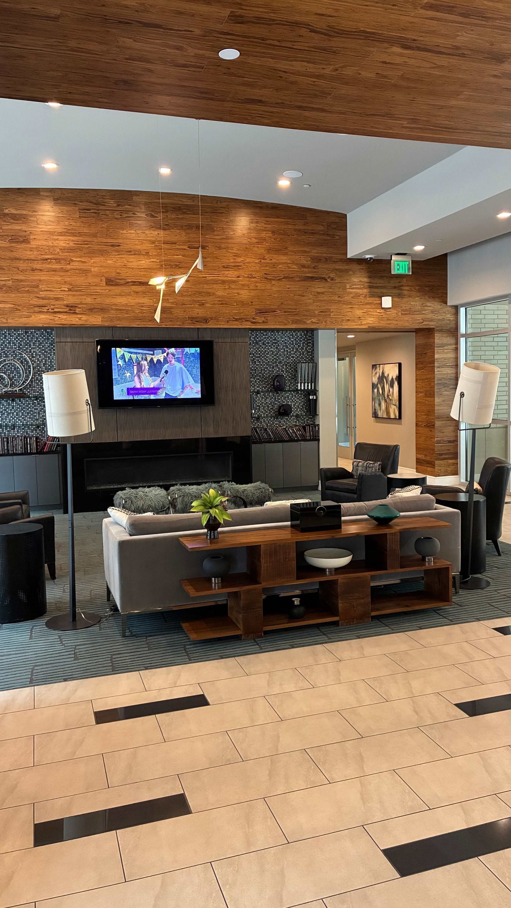 A modern living room with a flat-screen TV, sofas, a coffee table, and a fireplace.
