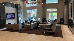 A modern living room with a flat-screen TV, comfortable seating, and large windows offering a view of the outdoors. - Preston Douglas Single I Premium 1BR in Dallas (Dallas)