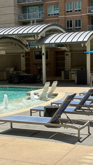A pool area with lounge chairs and a water feature. - Preston Douglas Double I Premium 2BR in Dallas (Dallas)