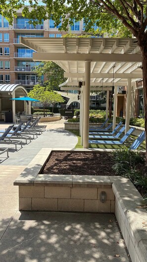 A covered outdoor area with lounge chairs and a pool. - Preston Douglas Double I Premium 2BR in Dallas (Dallas)