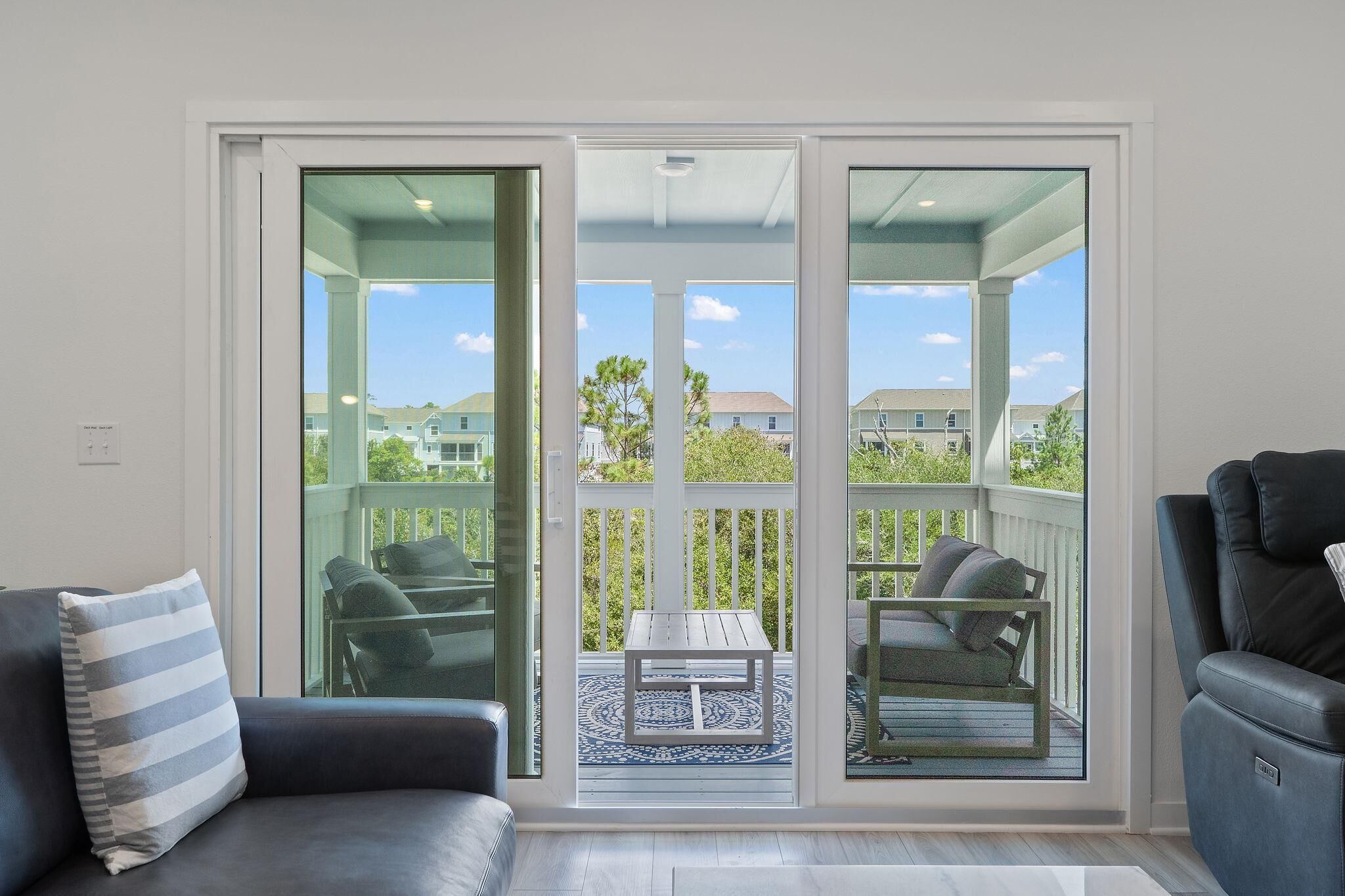 Een kamer met een schuifdeur naar een balkon met buitenmeubilair.