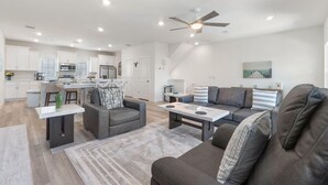 A modern living space with a kitchen, dining area, and seating area. - Over the Dunes at Lost Key Villas (Pensacola)
