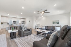 A modern living space with a kitchen, dining area, and seating area. - Over the Dunes at Lost Key Villas (Pensacola)