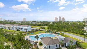 A residential area with a swimming pool, multiple-story buildings, and a clear view of the ocean. - Over the Dunes at Lost Key Villas (Pensacola)