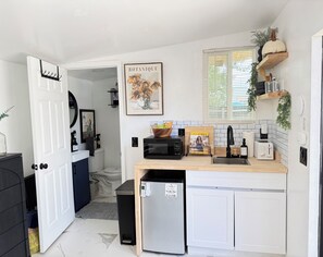 A compact kitchen with a microwave, toaster, and a small refrigerator.