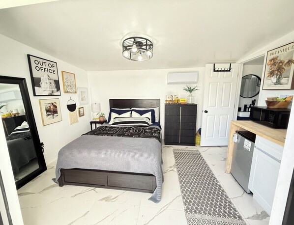 A bedroom with a bed, bedside tables, a wardrobe, a mirror, and a door.