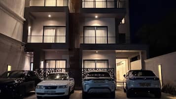 Un immeuble à plusieurs étages avec un espace de stationnement à l’avant.