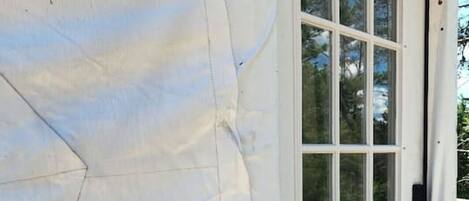 A white tent-like structure with a door and windows, suggesting a temporary accommodation setup.