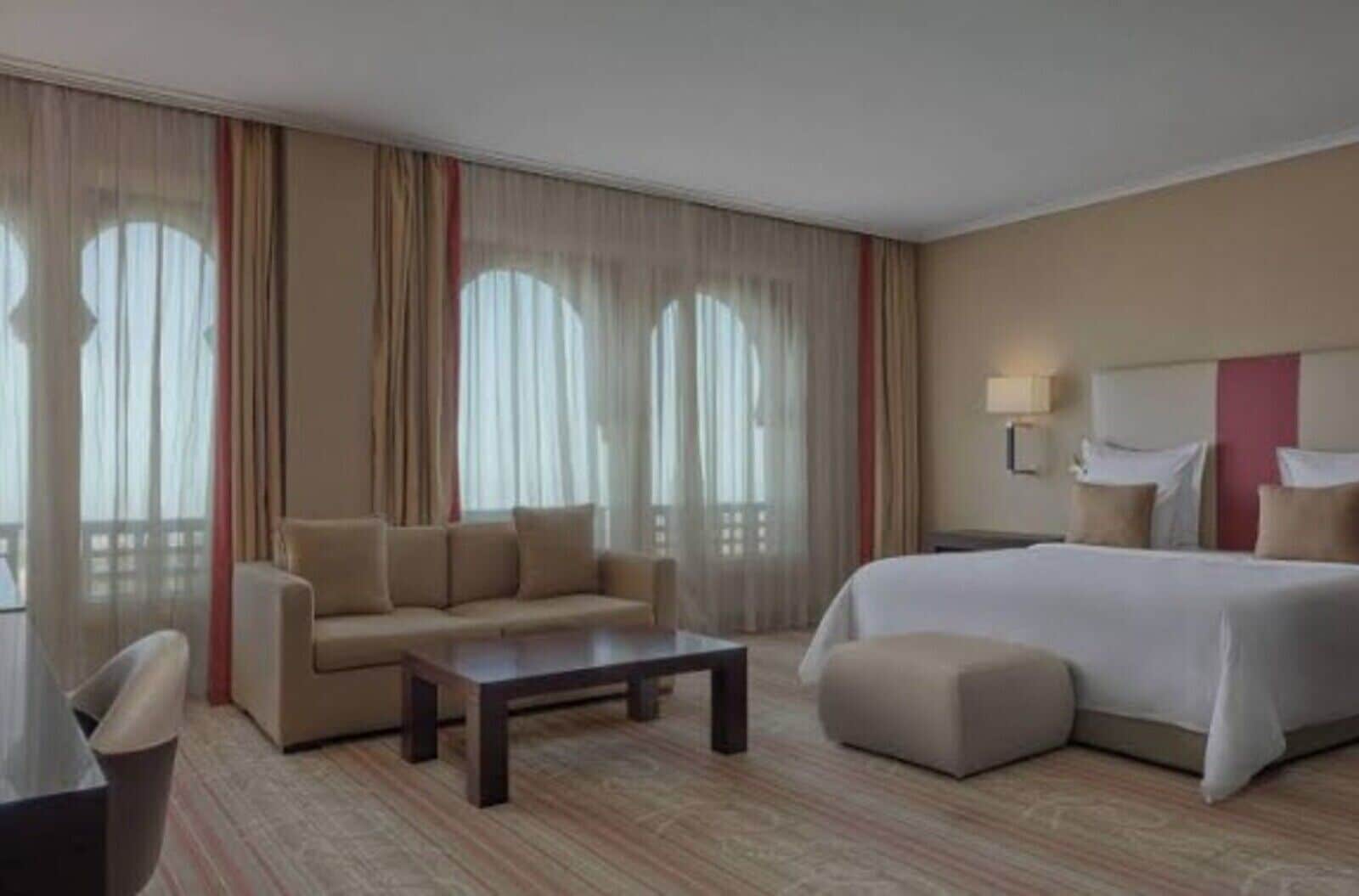 Une chambre d’hôtel avec un lit, un canapé, une table basse et une chaise.