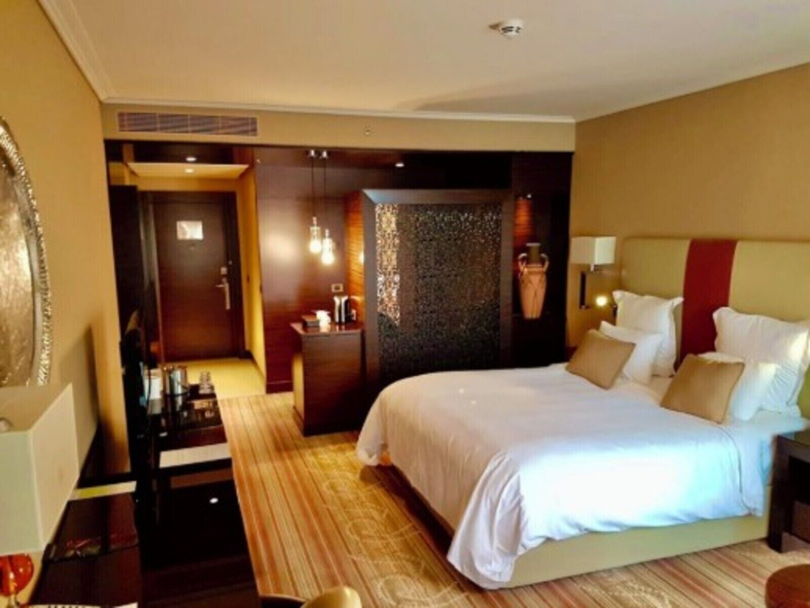 A hotel room with a large bed, a desk, and a seating area.