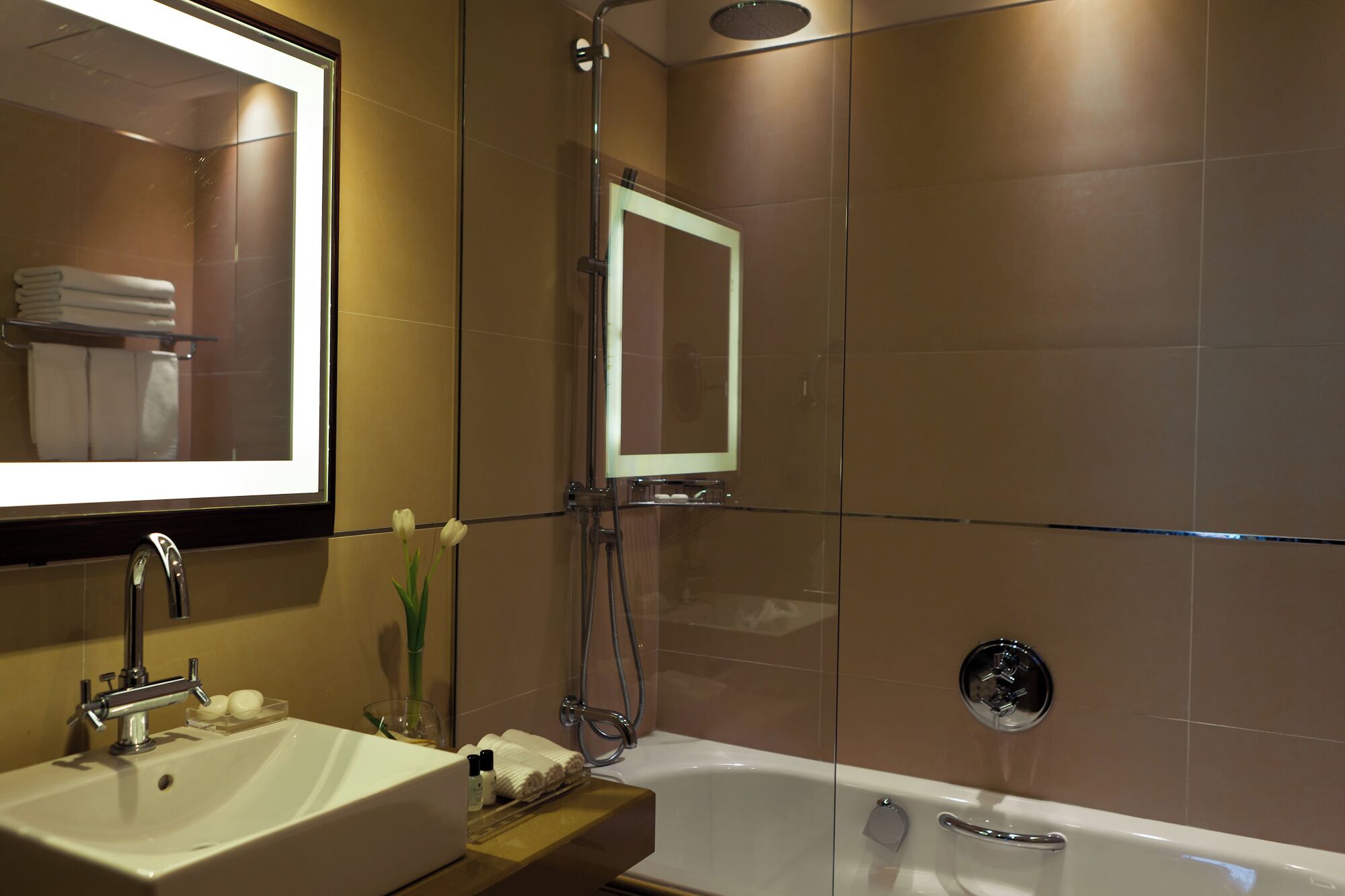 Un bagno moderno con lavandino, specchio e vasca da bagno.