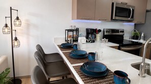 A modern kitchen with a central island, stainless steel appliances, and a pendant light fixture. - Brand New Apt Avitat Unique: Beauty Modern Cozy Great View. (San salvador)
