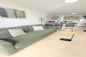 A modern living area with a sofa, a dining table, and a kitchen in the background. - Brand New Apt Avitat Unique: Beauty Modern Cozy Great View. (San salvador)