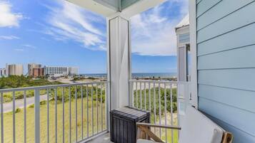 A balcony with a view of the beach and cityscape.
