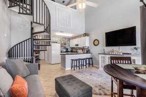 A modern living space with a kitchen, dining area, and a staircase. - Grand Caribbean 423 (Orange Beach)