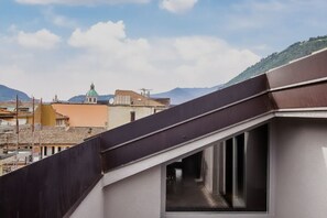 Eine Dachterrasse mit Blick auf Stadt und Berge.