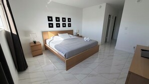A modern bedroom with a wooden bed, bedside tables, a flat-screen TV, and a wall-mounted light fixture. - Beauty apt Sunny Isles, 16th Floor. Great views! (Sunny Isles Beach)