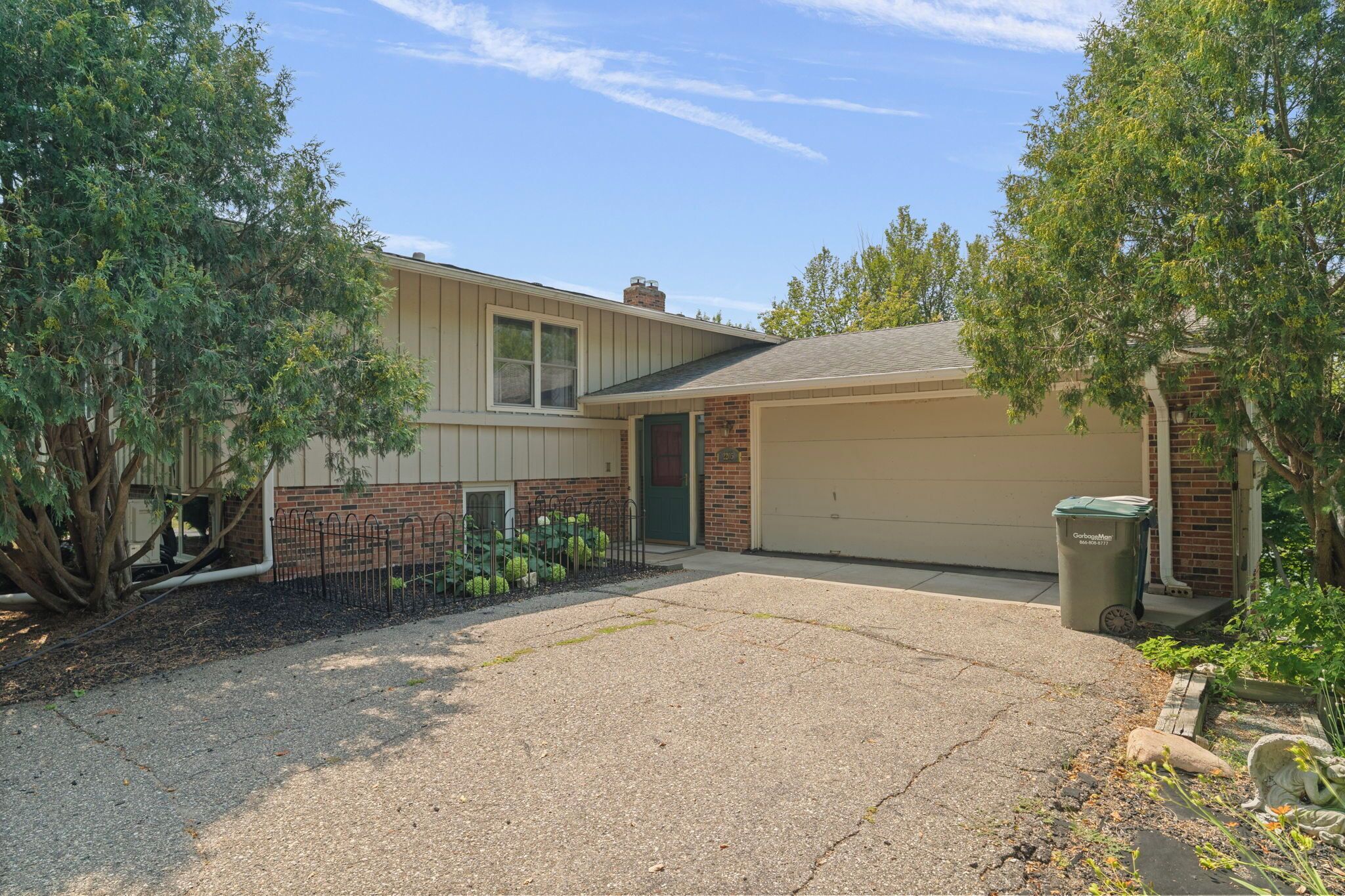 A residential property with a garage, a driveway, and a well-maintained lawn.