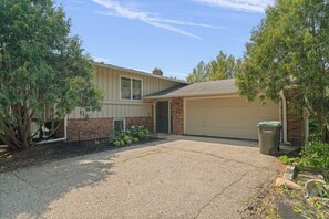 A residential property with a garage, a driveway, and a well-maintained lawn. - Solara on the Lake (Plymouth)