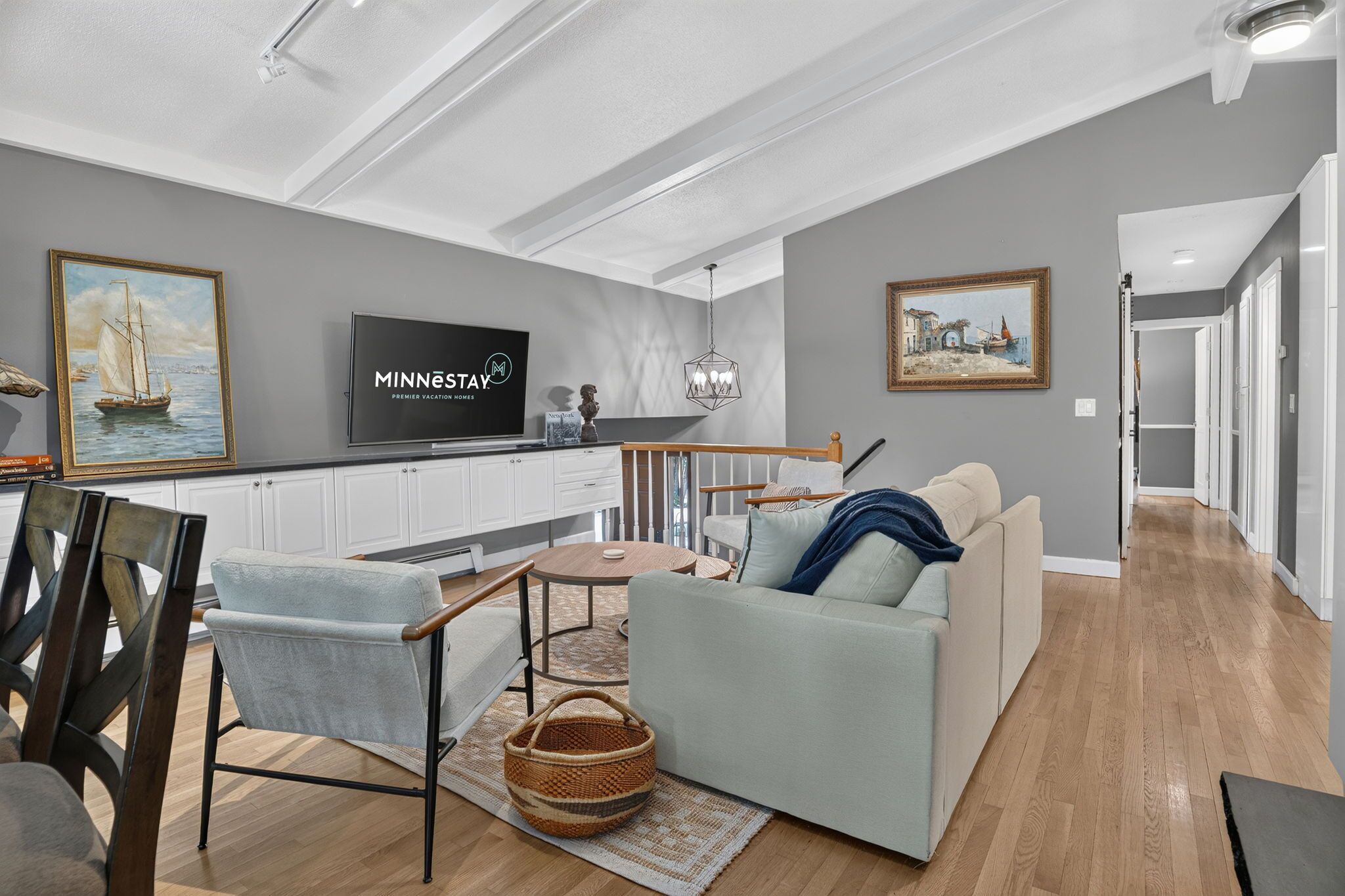 A modern living room with a sofa, coffee table, and a TV mounted on the wall.