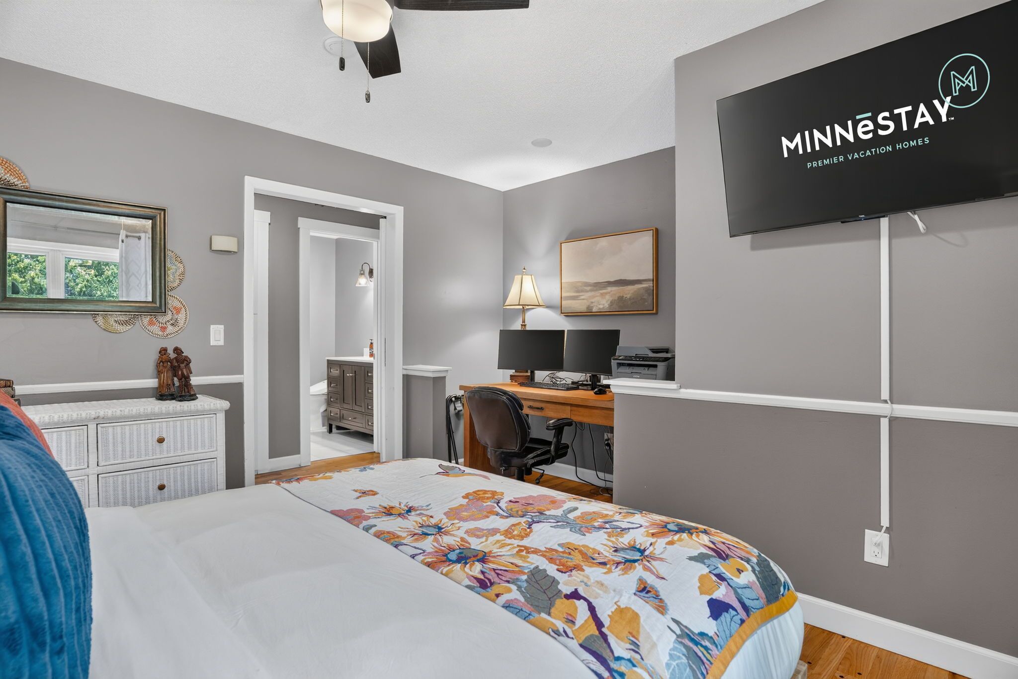 A bedroom with a bed, a desk, a chair, a TV, and a wardrobe.