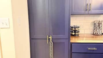 Una cucina con pensili scuri, un piano di lavoro in legno e un porta asciugamani a parete.