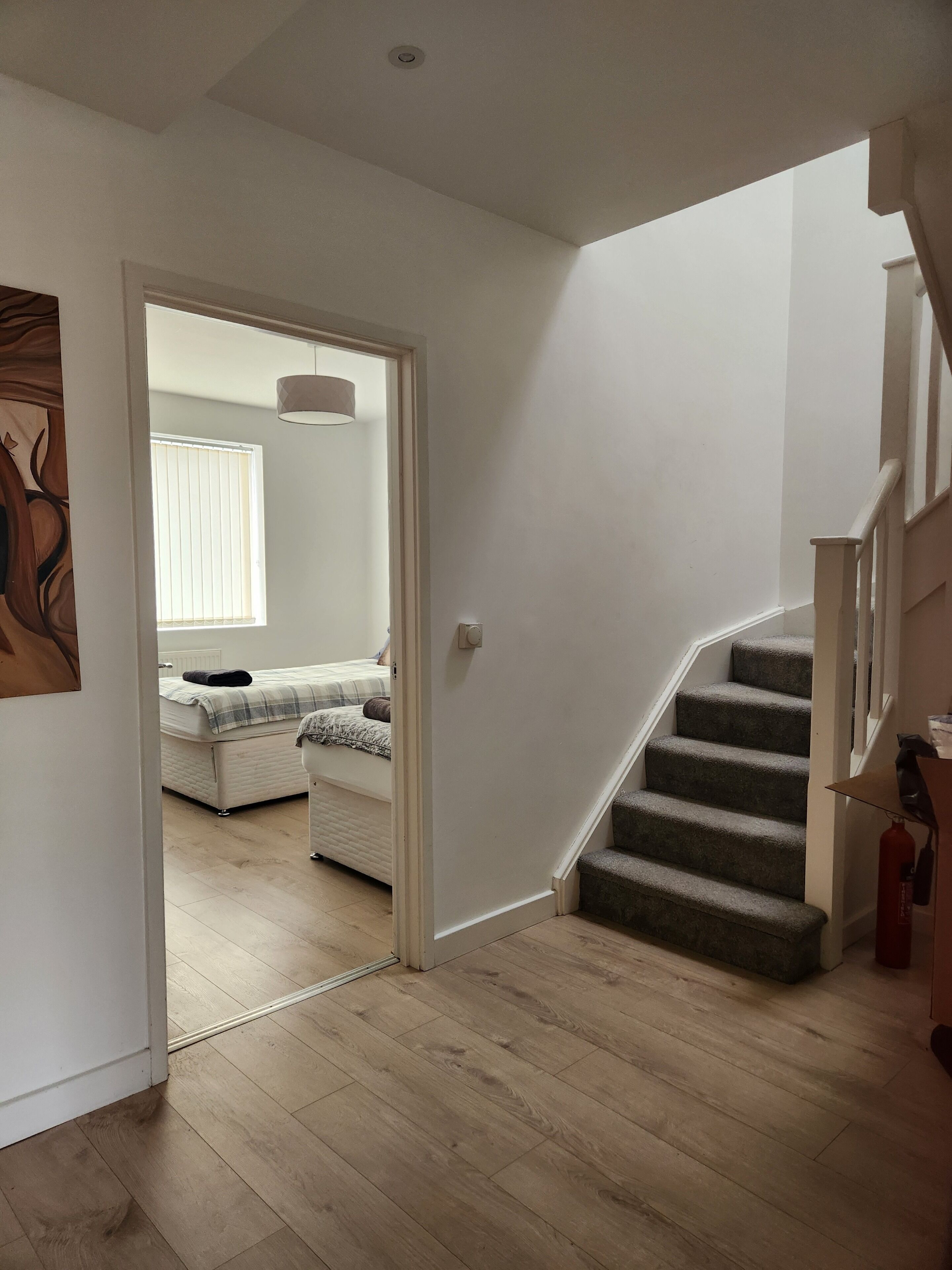 A staircase leading to a bedroom with a bed and a window.