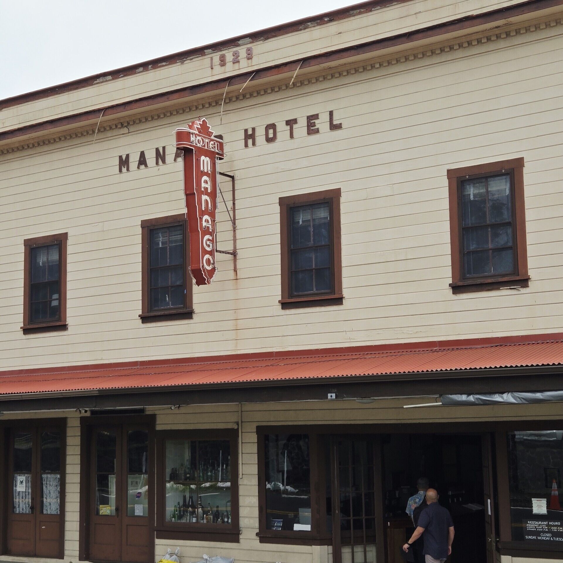Et hotel med en klassisk facade, tydelig skiltning og rødt tag.