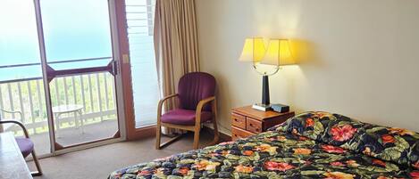 Une chambre d’hôtel équipée d’un lit, d’une chaise, d’un bureau, d’une lampe et d’un ventilateur de plafond.