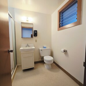 A small bathroom with a toilet, sink, and a mirror above the sink.