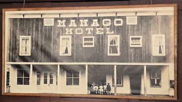 A building labeled 'MANAGO HOTEL' with multiple windows and a group of people at the entrance.