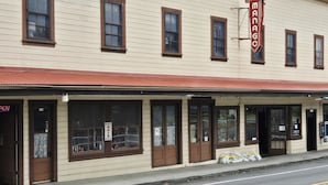 A two-story building with a sign reading 'MANACO HOTEL' and a 'NIKKI'S HAIR SALON' on the ground floor. - Manago Hotel (Captain Cook)