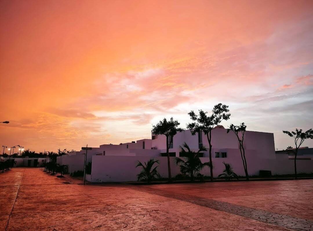 A building with a flat roof and a paved courtyard.