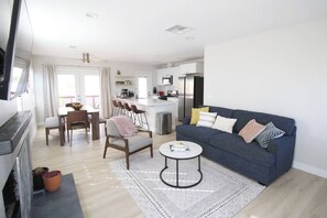 Uma sala de estar moderna com um sofá, mesa de centro e área de jantar.