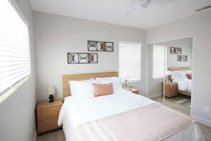 Ein Schlafzimmer mit einem Bett, Nachttischen, einem Spiegel und Bildern an der Wand.