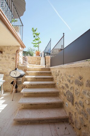 A stone staircase leading to a balcony with a view of the sky and a tree. - The hidden garden... with a sauna! (Torri del Benaco)