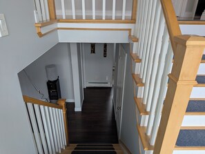 Un escalier avec une rampe en bois et des balustrades blanches menant à un palier.