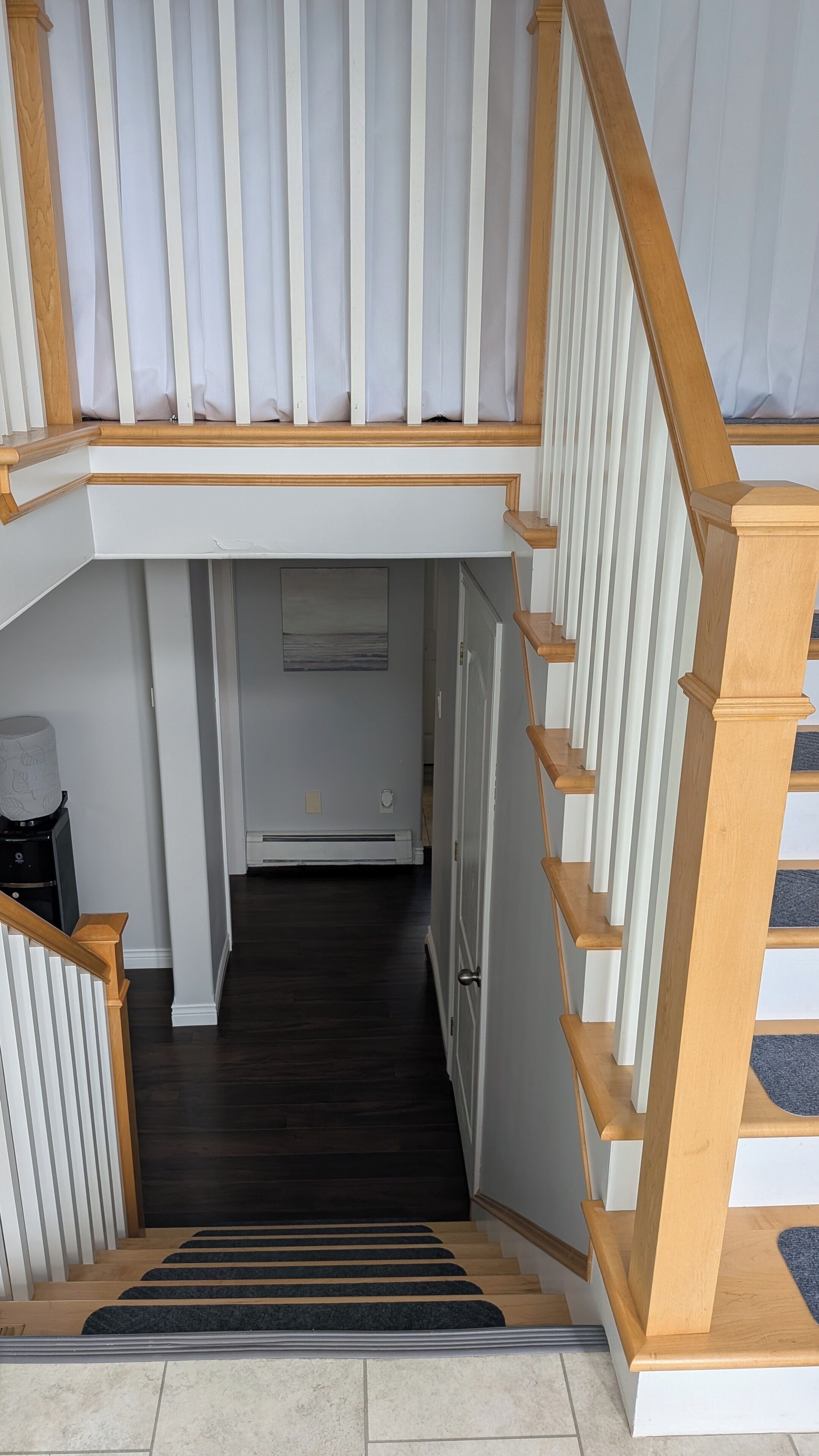 Una escalera con barandillas de madera y un rellano alfombrado.